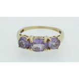 A 9 carat gold three stone amethyst ring - size N.