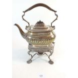 A silver tea kettle on stand with burner, half gadrooned decoration and silver scroll and shell feet