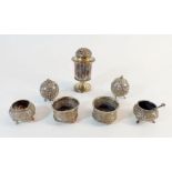 An Indian white metal four piece cruet set, two white metal salts and a large pepper pot