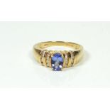 An 18 ct gold ring set tanzanite on diamond set stepped shoulders, size N