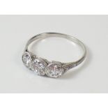 A white gold or platinum set three stone diamond ring, Size N