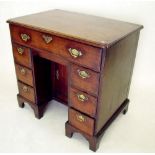 A George III mahogany small kneehole desk with secretaire drawer and replacement brass handles 83