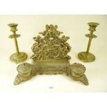 A brass baroque stye correspondence rack and a pair of brass candlesticks