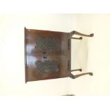 A Chinese hardwood two door cabinet with carved decoration to doors and sides, all raised on tall