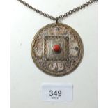 An Eastern Indo-Chinese gilt white metal disk pendant set with semi-precious stones - 6.5cm