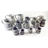 A group of thirteen pewter tankards and measures and a pewter beaker