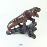 An Indo Chinese carved wood model of a stylised tiger 13cm tall