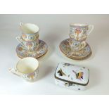 A Royal Worcester set of five coffee cups and saucers No 6981 and a porcelain box painted