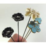 A pair of 'FMN' (Forget Me Not) floral hat pins, two white metal floral ones and a bone one