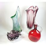 A tall purple art glass vase and a similar bowl, a green art glass jug and a red decanter