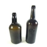 A 19th century green glass bottle with pontil mark and a later one with seal for All Souls Common