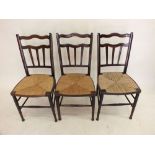 A set of three rush seated 1920?s stained beech dining chairs