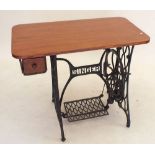 A Singer treddle sewing machine table with replacement top and cast iron base