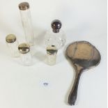 A Victorian cut glass and silver topped scent bottle, four glass and silver topped toiletry