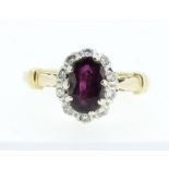 An 18 carat gold ruby and diamond cluster ring, size K