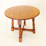 An oak circular occasional table on turned supports