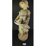 An early 20th century Art Nouveau plaster figure of a young girl carrying a basket of puppies, 52cm.