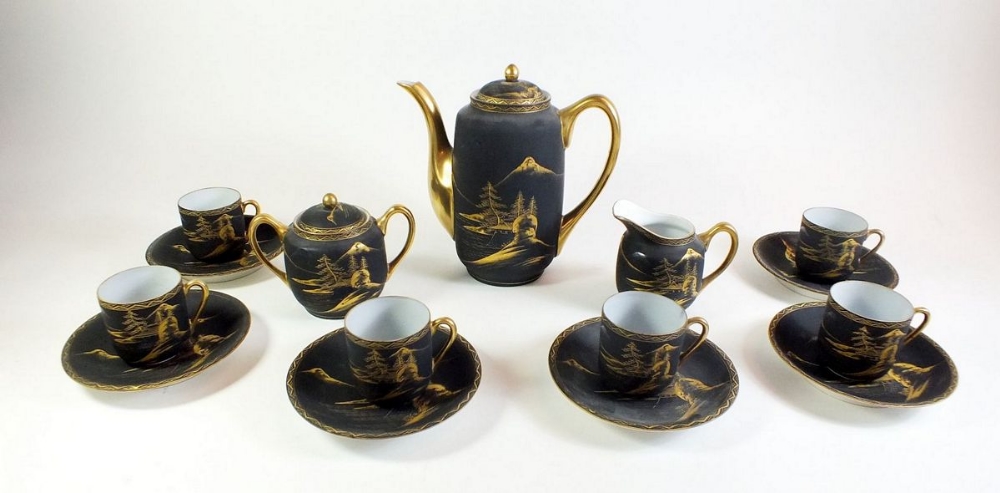 A Japanese black and gilt coffee set comprising:-coffee pot, milk, sugar and six cups and saucers