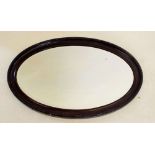 An oval mahogany finish mirror, 76 x 48cm