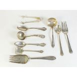 A group of nine items of American sterling silver cutlery to include mote spoon, sauce ladles, caddy