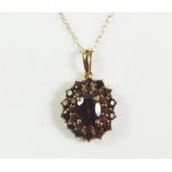 A 9ct gold pendant set with garnets on chain.