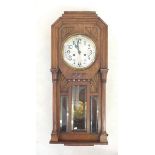 A 1920s oak cased wall clock with twin column and Art Deco symmetrical designs, 71cm tall