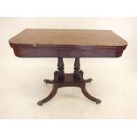 A Victorian mahogany card table with rectangular fold top raised on twin turned supports,