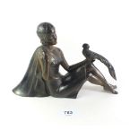 A 1920s patinated spelter Art Deco figurine of a reclining woman with a pheasant on knee, signed