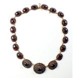 A Victorian yellow metal garnet necklace with nineteen graduated links