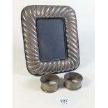 A silver gadrooned photograph frame London 1986 and two silver napkin rings