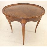 An oak circular occasional table on slender supports