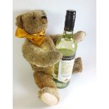 A mid 20th century gold plush teddy bear with hump back and growler