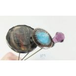 A silver and enamel hat pin, silver and purple glass thistle form one and a feather hat pin