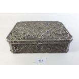 A silvered metal cast and embossed jewellery box with a rococo design of cherubs and foliage. 24cm
