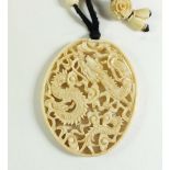 A late 19th century Chinese Canton ivory pendant carved with dragons, pendant size 5.8cm