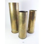 Three brass shell cases, largest 36cm