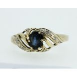 A 9 carat gold sapphire and chip diamond ring in swirl setting