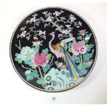 A 20th century Chinese plate painted bird on a black floral ground, 31cm diameter