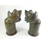 An unusual 19th century pair of cast bronze tribal figure heads, set on wooden mounts, probably