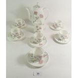A Wedgwood 'Flame Rose' coffee set comprising six cups and saucers, coffee pot and cream jug