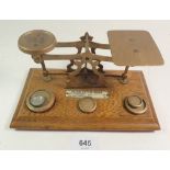 A set of brass and oak postal scales