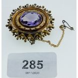 A Victorian yellow metal oval brooch set amethyst