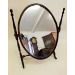 An Edwardian mahogany oval swing toiletry mirror