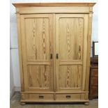 A late Victorian pine wardrobe with two doors over two drawers (knock down construction) 204cm H x
