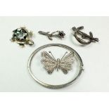A silver bangle and four silver brooches.