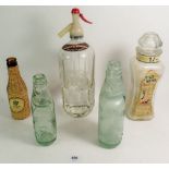 A Schweppes soda syphon and various old bottles
