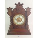 An Ansonia mantel clock in carved case with key and pendulum