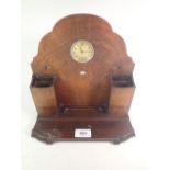 An Art Deco walnut desk tidy incorporating clock, perpetual calendar windows and pen holders. 25cm