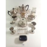 A box of silver plated items including tea set, toast rack and candlestick