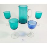A green glass jug, three green glasses and a blue glass